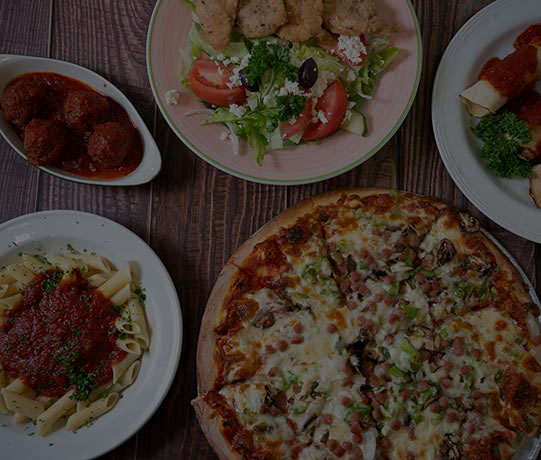 images of food served at Station Pizza. Single plate of meatballs in homemade tomato sauce, plate with greek salad and chicken bites, side image of homemade cannoli and tomato sauce, stationmaster pizza and the final dish of penne in homemade tomato sauce.