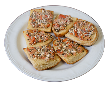 plate of six square pieces of garlic bread topped with tomatoes, onions, feta cheese, olive oil.