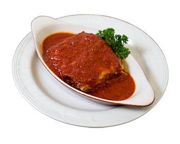 plate holding a lasagna bowl with a slice of meat lasaga topped with homemade tomato sauce and garnished with parsley