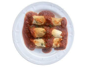 plate of three manicotti stuffed with ricotta, mozzerella rolled in a homemade crepe and topped with homemade tomato sauce.