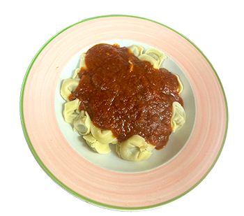 plate of meat tortellini and topped with homemade tomato sauce.